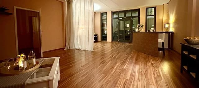 Heller Eingangsbereich des Studios mit Holzboden und großen Fenstern