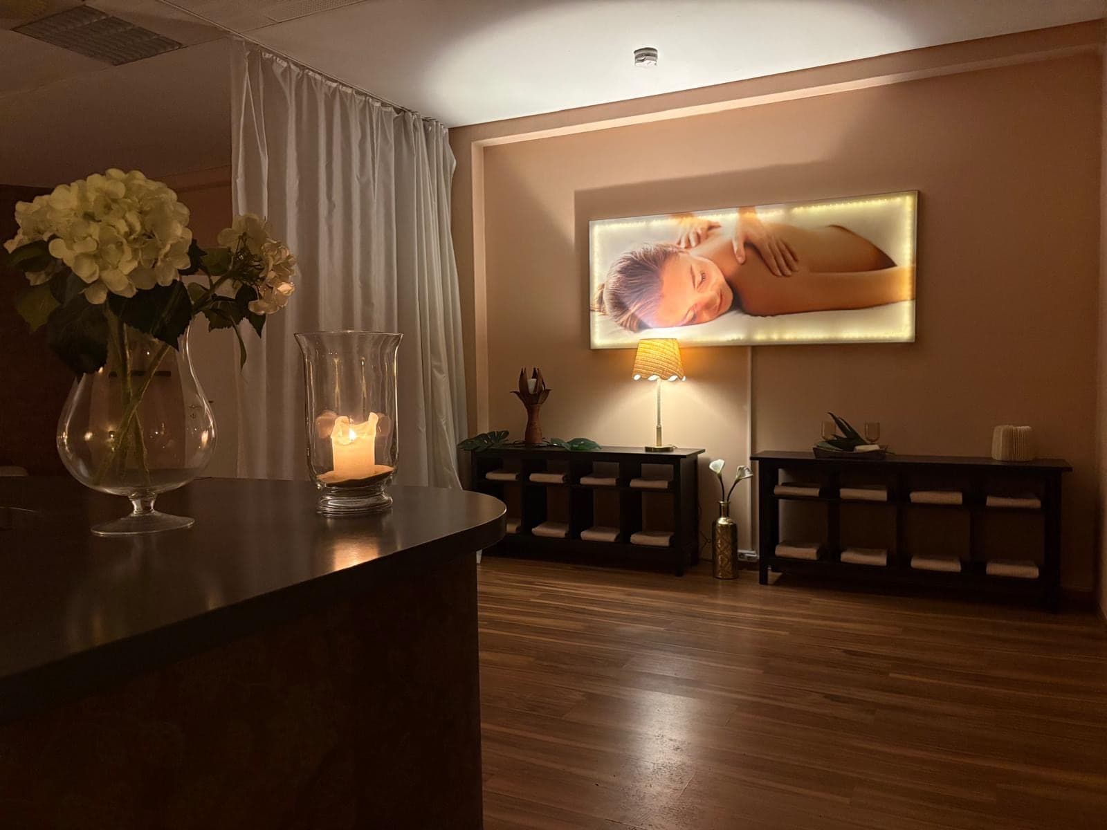 Empfang des Massagestudios in der Jacobstraße 5 mit Kerze, Blumen und beleuchtetem Wandbild