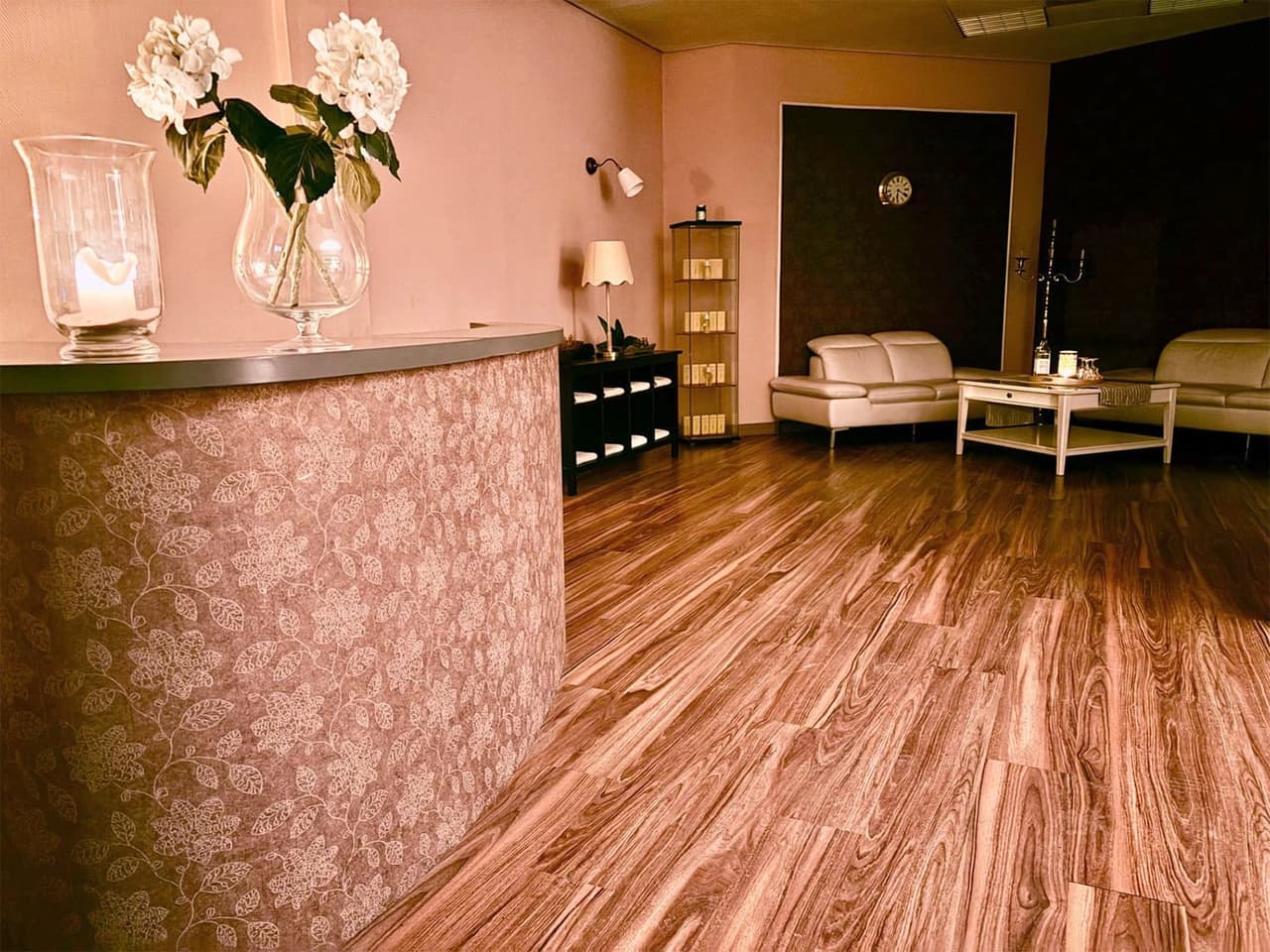 Lobby von Meine Massage mit Empfangstresen, heller Sitzgruppe und Holzboden